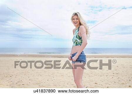 Stock Image - Portrait of young woman on beach. Fotosearch