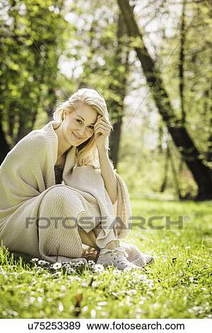 Portrait of young woman wrapped in blanket in forest View Large Photo Image Stock Photo - Portrait of young woman wrapped in blanket in forest. Fotosearch