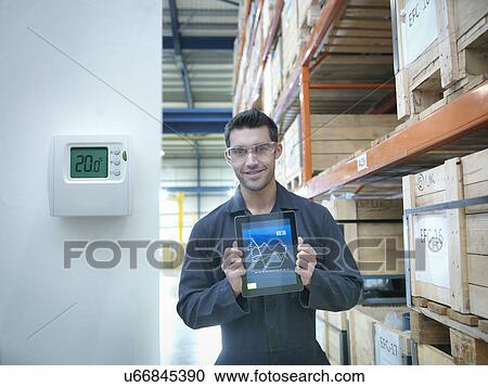 Proud factory worker showing energy saving on digital tablet in factory, portrait View Large Photo Image Stock Image - Proud factory worker showing energy saving on digital tablet in factory, portrait. Fotosearch