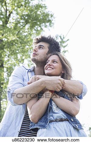 Romantic young couple gazing upward View Large Photo Image Stock Image - Romantic young couple gazing upward. Fotosearch