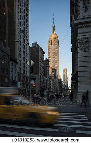 Stock Image - Street view of New York with Empire State Building in view. Fotosearch