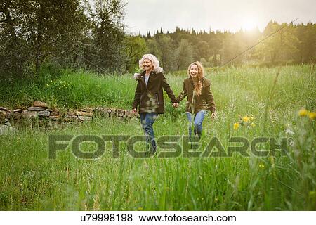 Teenage daughter and mother strolling in field View Large Photo Image Stock Photo - Teenage daughter and mother strolling in field. Fotosearch