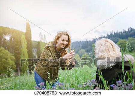 Teenage daughter photographing mother on smartphone View Large Photo Image Stock Image - Teenage daughter photographing mother on smartphone. Fotosearch