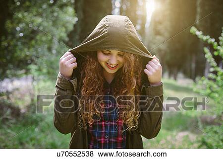 Stock Photo - Teenage girl in hooded top in forest. Fotosearch