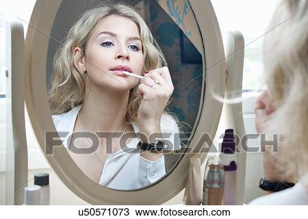 Teenage girl looking in mirror, applying make-up View Large Photo Image Stock Image - Teenage girl looking in mirror, applying make-up. Fotosearch