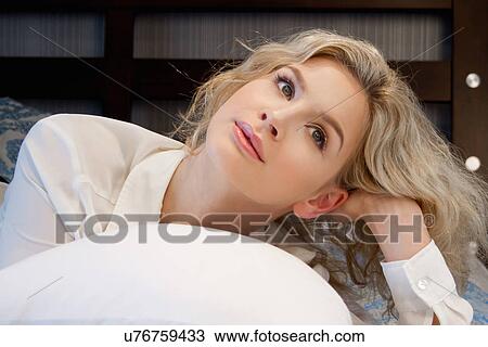 Stock Image - Teenage girl lying on bed. Fotosearch