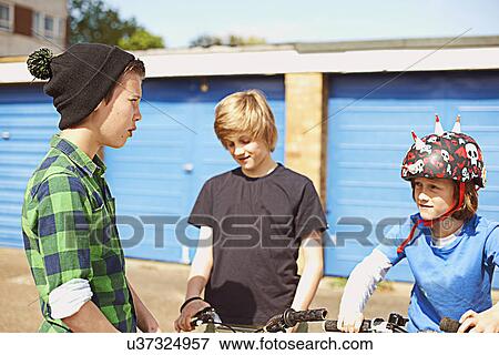 Three boys talking near garages View Large Photo Image Stock Photo - Three boys talking near garages. Fotosearch