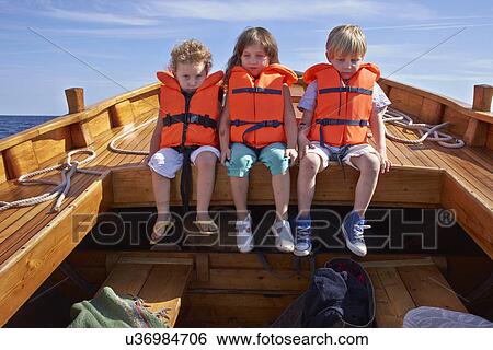 Three children sitting in boat View Large Photo Image Stock Photograph - Three children sitting in boat. Fotosearch