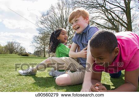 Stock Photo - Two boys and a girl playing in field. Fotosearch