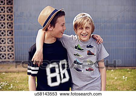 Stock Image - Two boys with arms around each other, portrait. Fotosearch