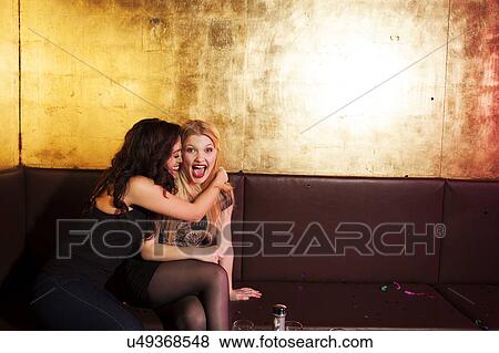 Two female friends having a laugh in nightclub View Large Photo Image Stock Photo - Two female friends having a laugh in nightclub. Fotosearch