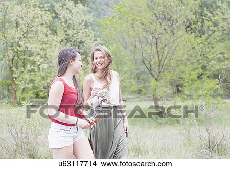 Picture - Two female friends strolling and chatting, Piemonte, Italy. Fotosearch