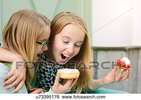 Two happy sisters holding cakes View Large Photo Image Stock Photo - Two happy sisters holding cakes. Fotosearch