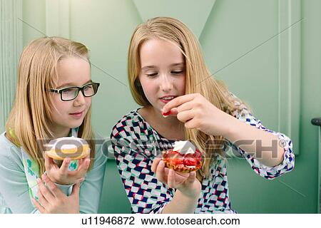 Two sisters holding cakes and strawberry View Large Photo Image Stock Image - Two sisters holding cakes and strawberry. Fotosearch