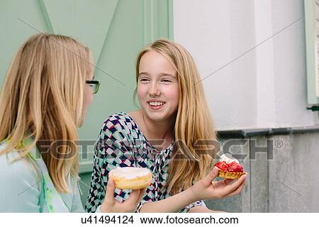 Picture - Two sisters holding cakes. Fotosearch