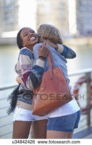 Stock Photograph - Two young female friends hugging. Fotosearch