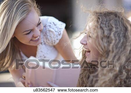 Two young female friends laughing View Large Photo Image Stock Photo - Two young female friends laughing. Fotosearch