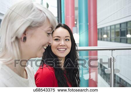 Stock Photography - Two young women laughing, portrait. Fotosearch