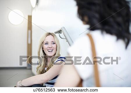 Stock Image - Two young women talking. Fotosearch