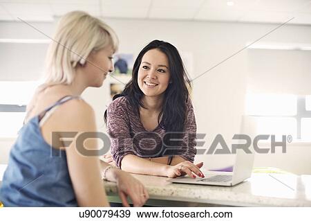 Two young women using laptop View Large Photo Image Stock Photo - Two young women using laptop. Fotosearch