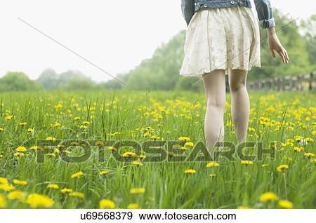 Waist down rear view of young woman strolling in field View Large Photo Image Stock Photo - Waist down rear view of young woman strolling in field. Fotosearch