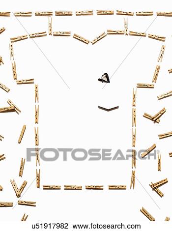 Stock Image - White tshirt outlined with clothespins on white background. Fotosearch