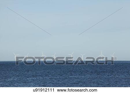 Stock Image - Wind turbines on sea horizon, Conway, Gwynedd, Wales UK. Fotosearch