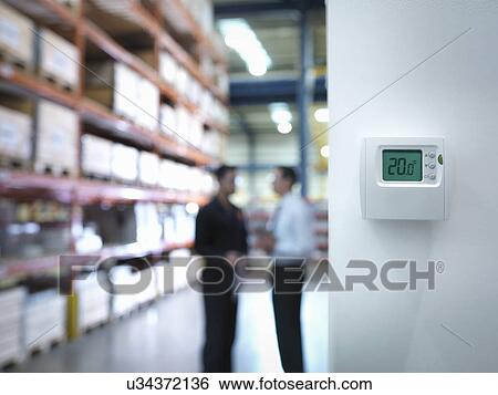 Worker and office manager discuss energy use near thermostat in factory View Large Photo Image Stock Photograph - Worker and office manager discuss energy use near thermostat in factory. Fotosearch