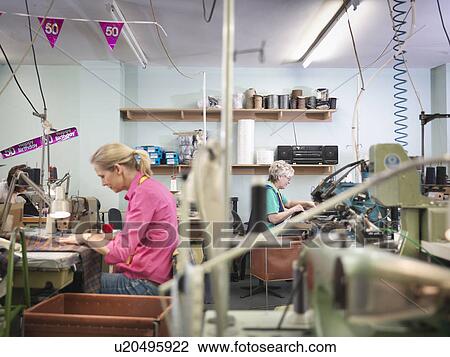 Stock Image - Workers sewing in clothing factory. Fotosearch