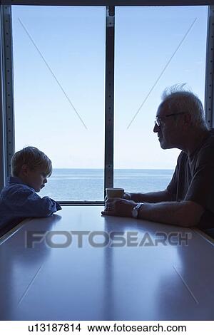 Young boy and father sitting at table on ferry View Large Photo Image Picture - Young boy and father sitting at table on ferry. Fotosearch