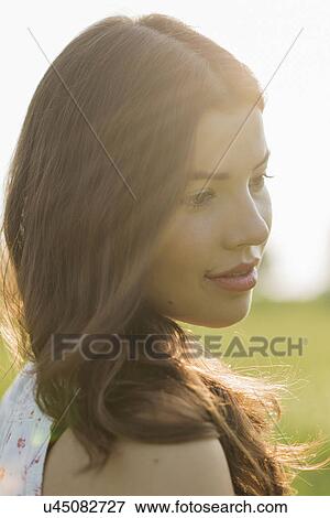 Stock Photo - Young brunette woman in sunlight, portrait. Fotosearch