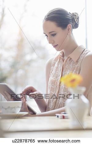 Young businesswoman in cafe using digital tablet View Large Photo Image Stock Photography - Young businesswoman in cafe using digital tablet. Fotosearch