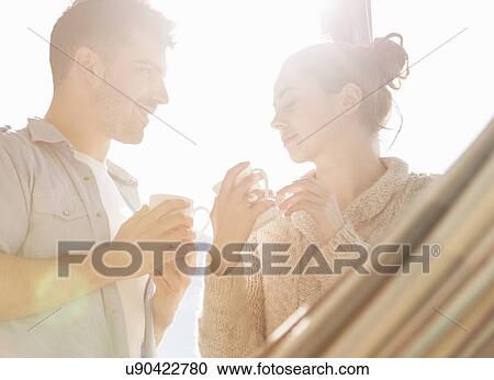 Young couple drinking cups of coffee View Large Photo Image Stock Image - Young couple drinking cups of coffee. Fotosearch