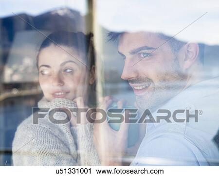 Young couple looking through window View Large Photo Image Stock Image - Young couple looking through window. Fotosearch