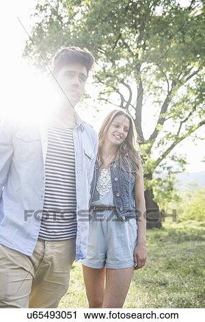 Young couple strolling in sunlight View Large Photo Image Stock Image - Young couple strolling in sunlight. Fotosearch