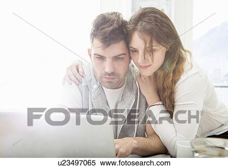 Stock Photography - Young couple using laptop. Fotosearch