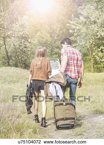 Young couple with wheeled suitcase heading for pick-up truck, Piemonte, Italy View Large Photo Image Stock Image - Young couple with wheeled suitcase heading for pick-up truck, Piemonte, Italy. Fotosearch