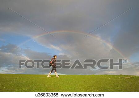 Young female hiker, hiking below rainbow View Large Photo Image Stock Photography - Young female hiker, hiking below rainbow. Fotosearch