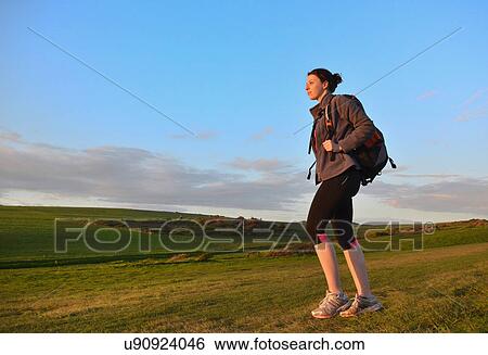 Stock Photograph - Young female hiker, hiking in hills. Fotosearch