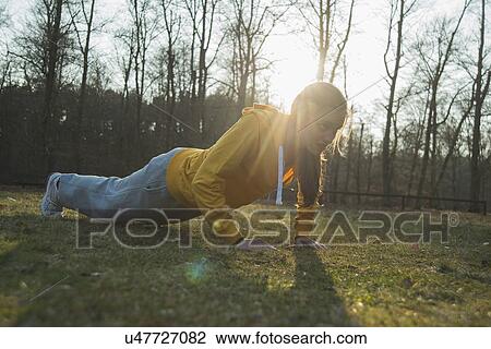 Young female runner doing warm up press ups View Large Photo Image Stock Image - Young female runner doing warm up press ups. Fotosearch