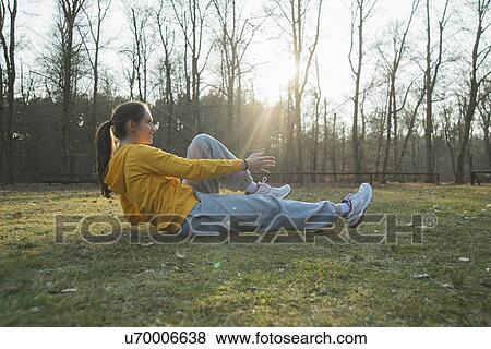 Young female runner doing warm up sit ups View Large Photo Image Stock Photo - Young female runner doing warm up sit ups. Fotosearch