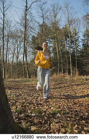 Young female runner in autumn forest View Large Photo Image Stock Image - Young female runner in autumn forest. Fotosearch