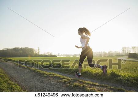 Young female runner on dirt track View Large Photo Image Stock Photograph - Young female runner on dirt track. Fotosearch