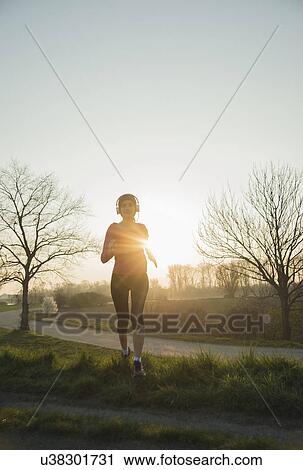 Young female runner, running at sunset View Large Photo Image Stock Image - Young female runner, running at sunset. Fotosearch