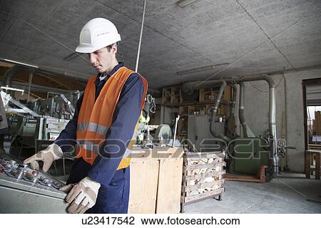 Young male woodworker operating machine control panel View Large Photo Image Stock Image - Young male woodworker operating machine control panel. Fotosearch
