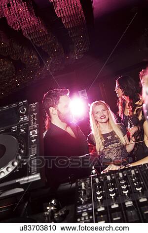 Stock Image - Young man and women flirting in nightclub. Fotosearch