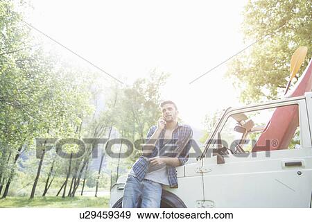 Young man leaning against off road vehicle View Large Photo Image Stock Photo - Young man leaning against off road vehicle. Fotosearch