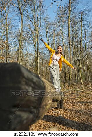 Young woman balancing on log on forest assault course View Large Photo Image Stock Photography - Young woman balancing on log on forest assault course. Fotosearch