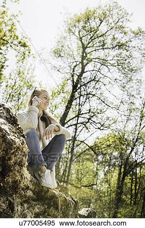 Young woman chatting on smartphone in forest View Large Photo Image Stock Photography - Young woman chatting on smartphone in forest. Fotosearch