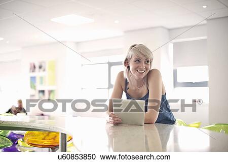 Stock Image - Young woman holding digital tablet. Fotosearch